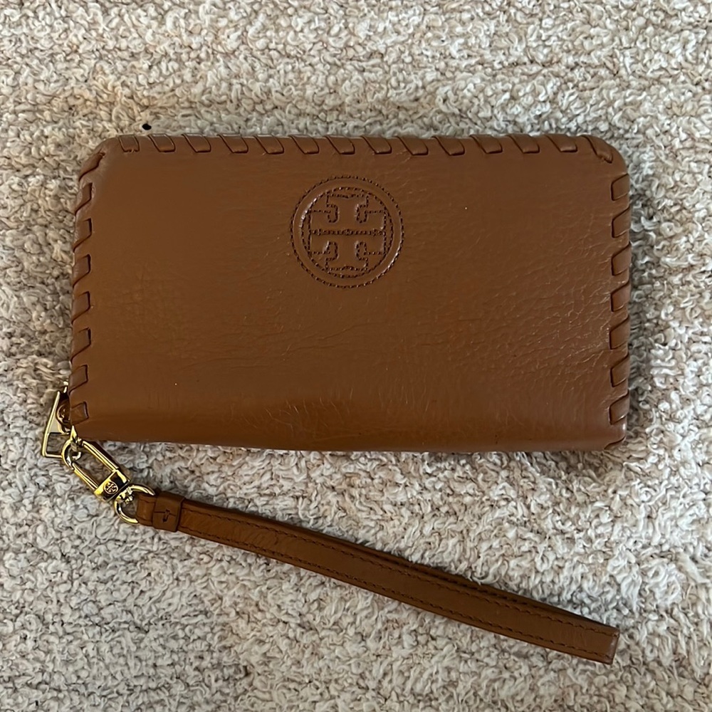 Tory Burch tan wallet. Comes with wrist band. Lightly worn.
